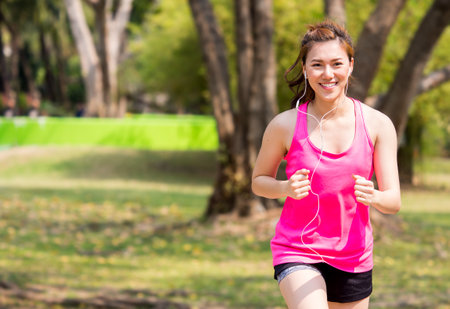Woman fitness outdoor concept, young asian beautiful woman/sport girl running walking at outdoor park with fresh, relax, happy feeling.の写真素材