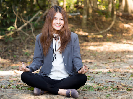 Young asian businesswoman yoga in forest, relaxing for working meditation, business lifestyle and wellbeing conceptの写真素材