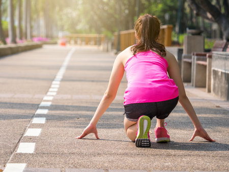 Beautiful young asian woman at starting line for running jogging fitness outdoor, ready to start, sport woman fitness outdoor conceptの写真素材