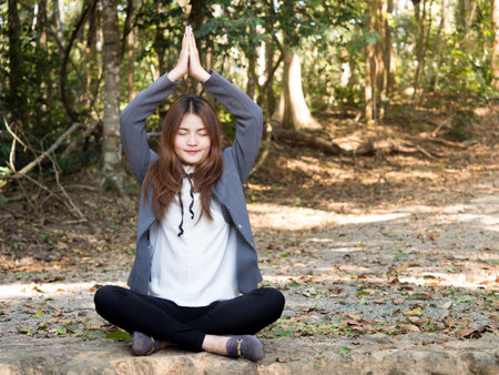 Young asian businesswoman yoga in forest, relaxing for working meditation, business lifestyle and wellbeing conceptの写真素材