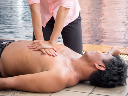 Woman rescues unconscious man by checking breath Then CPR and giving artificial respirationの写真素材