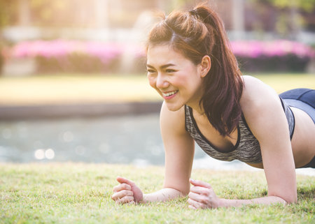 Woman workout outdoor concept, young asian beautiful woman/sport girl running walking and yoga at outdoor park with fresh, relax, happy feeling.の写真素材