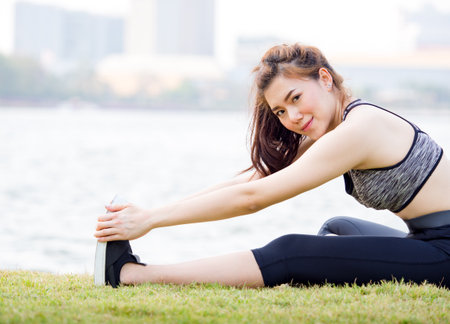 Woman fitness outdoor concept, young woman stretching for sport workout, yoga, running at park in the morning, fresh, relax and happy feelingの写真素材