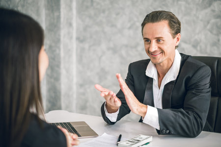 Boss/Business man employer admires young Asian business woman/staff/employee by thumb up and clap with smiling face for her success and good/best in work and recognition/appreciate.の写真素材