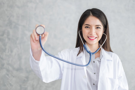 Asian woman doctor with stethoscope in uniform over background with copy space, medical conceptの写真素材
