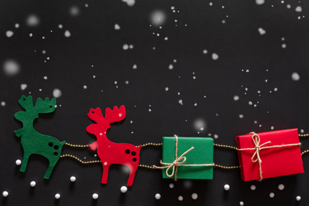 Reindeer carring gift and present box for christmas concept over black background with snow. topview flatlayの写真素材