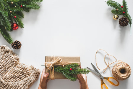 Hand making gift/presents box for christmas concept with decorations over white background and copy space. flatlayの写真素材