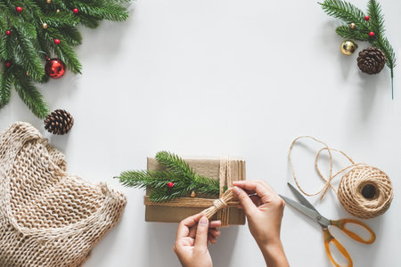 Hand making gift/presents box for christmas concept with decorations over white background and copy space. flatlayの写真素材