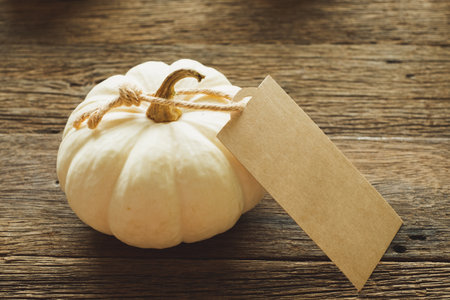 Thanksgiving background, pumpkin with tag, leaves and decoration on wood table background with copy space. flatlayの写真素材