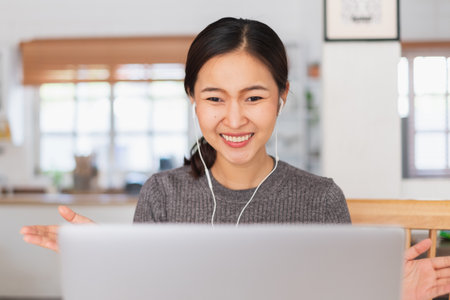 Young Asian businesswoman work at home and virtual video conference meeting with colleagues business people, online working, video call due to social distancingの写真素材