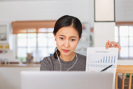 Young Asian businesswoman work at home and virtual video conference meeting with colleagues business people, online working, video call due to social distancingの写真素材