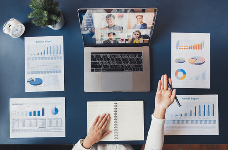 Young Asian businesswoman work at home and virtual video conference meeting with colleagues business people, online working, video call due to social distancing, top viewの写真素材