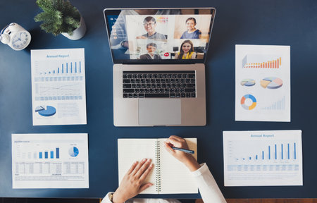Young Asian businesswoman work at home and virtual video conference meeting with colleagues business people, online working, video call due to social distancing, top viewの写真素材