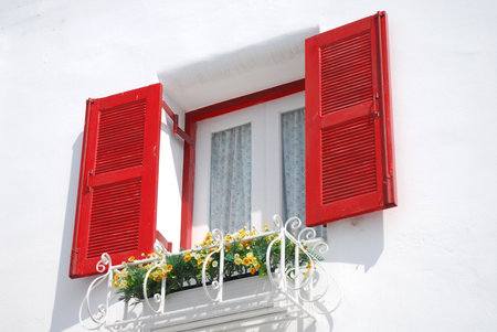 Red windows on the white wallの写真素材