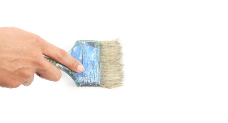 Hand holding painting brush on white canvasの写真素材