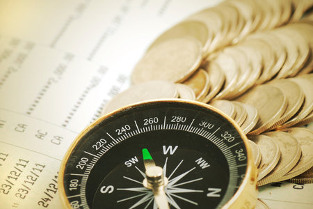 Coins and compass on bank book account in vintage colorの写真素材