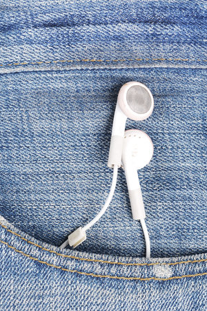 white earphone hanging out from jeans pocketの写真素材