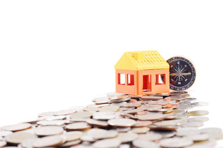 House model and compass on the way of coinsの写真素材