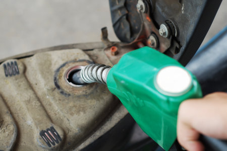Man putting gasoline fuel into his motorcycleの写真素材