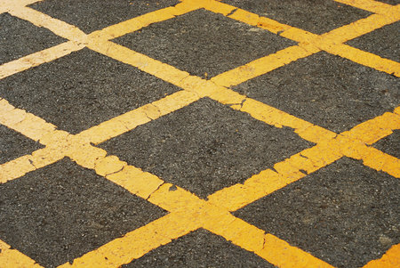 Asphalted road with yellow cross stripes