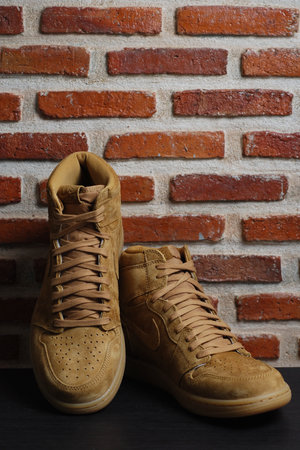 Nakhon Pathom, Thailand - March 16, 2019 : Nike Air Jordan 1 Retro High Wheat Gold. Sneaker with grunge wall background. Sneaker for Retro Lift style.のeditorial素材