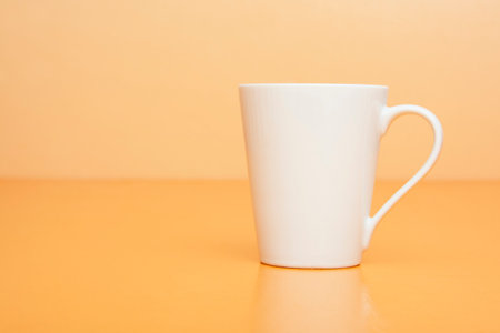 White Coffee Mug on Orange Backgroundの写真素材