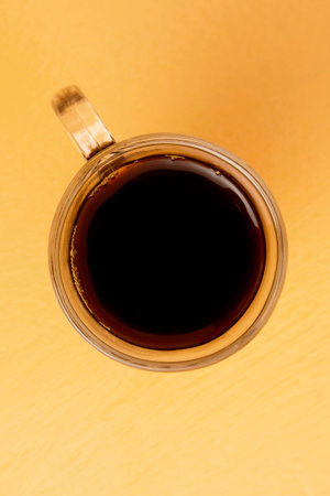 Glass Mug with Coffee, Viewed from the Top on Orange Backgroundの写真素材