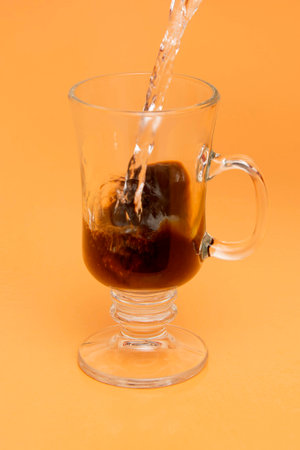 Pouring Water into Glass Mug, making Instant Coffeeの写真素材