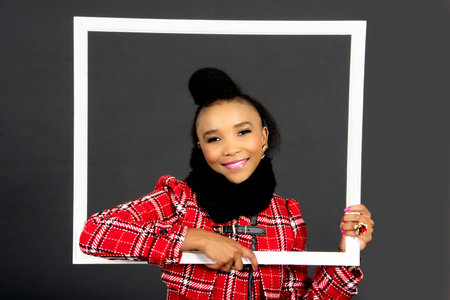 Beautiful African Female Model Holding  a Frame, in the Studio, Grey Background