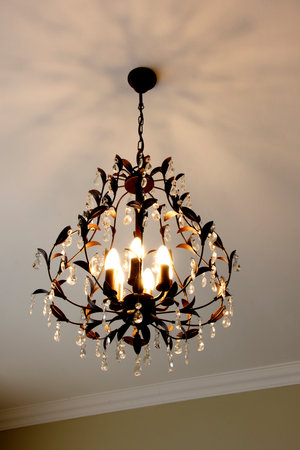 Beautiful Metal Chandelier with Floral Decorations, Crystals, and Multiple Bulbsの写真素材