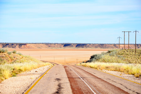 Traveling along a scenic tar road through a dry Koopan South Africa Africaの写真素材