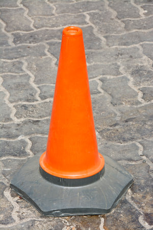Closeup of Single Orange Traffic Cone on a Paved Roadの写真素材