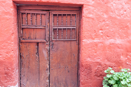 Brown old wooden doors in red houseの写真素材