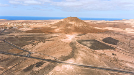 Aerial view of roads crossing desert landscape, panorama of volcanic mountains, coastline of Fuerteventura, Canary Islands, Spain .の写真素材