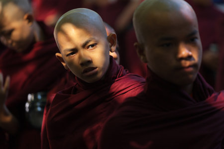 MANDALAY, MYANMAR - NOVEMBER 13 2014 - Monks line up for their morning meal at Mahagandayon...