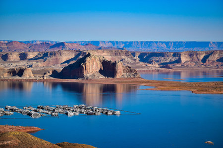 Boats docked in the lake near a mountain at Glen Canyonの写真素材