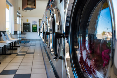 A row of heavy-duty washing machines at the laundromat.の写真素材