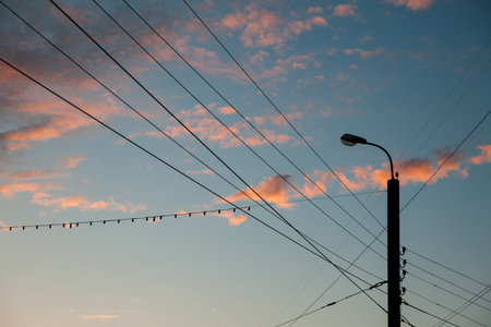 Silhouette of city lights and wires at sunset with blue sky amd pink cloudsの写真素材