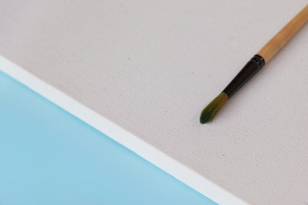 One brush for painting on textured blank white canvas background with copy space diagonally. Drawing education for beginners and inspiration concept.の写真素材