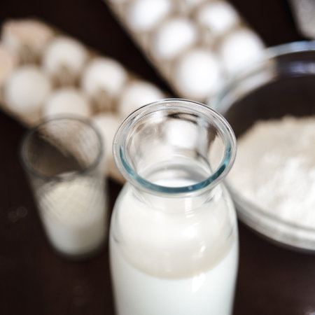 Home cooking still life of eggs in box and milk in glass bottle.