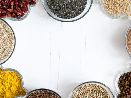 Superfoods in glassware on white background. Bright colorful flat lay of healthy food products with copy space.の写真素材