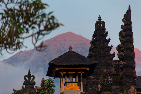 Balinese sacred mountain Agung colored in pink by sunset light. Main Bali temple Pura Besakih at the foot of the volcano Agung.の写真素材