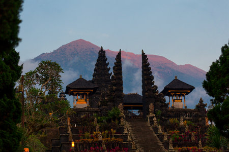 Balinese sacred mountain Agung colored in pink by sunset light. Main Bali temple Pura Besakih at the foot of the volcano Agung.の写真素材