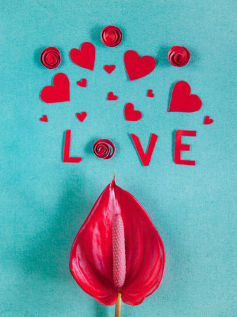 Overhead flat lay valentine day background. Red paper hearts and flowers handmade, kraft envelope letters with kiss print on blue texturred background. Bright inspiration for holiday of love.の写真素材