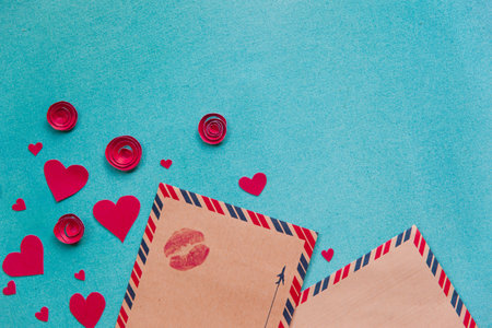 Overhead flat lay valentine day background. Red paper hearts and flowers handmade, kraft envelope...