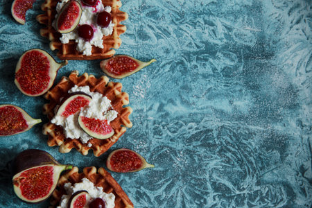 Overhead still life of belgian biscuit waffles with cottage cheese, fresh figs and cherry. Healthy vegetarian breakfast.の写真素材