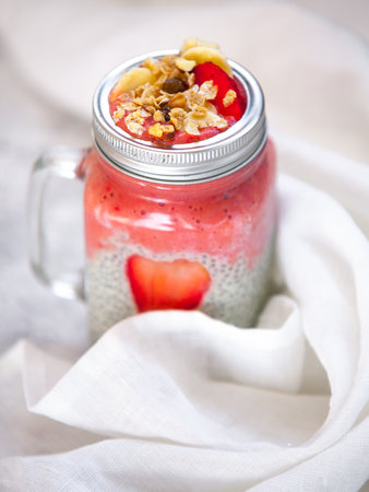 Layered chia pudding and strawberry-banana smoothie with berry slice and muesli. Vegan healthy diet concept.の写真素材