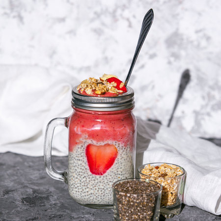 Layered chia pudding and strawberry-banana smoothie with berry slice and muesli. Vegan healthy diet concept.の写真素材
