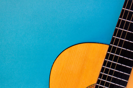 Acoustic classic guitar on blue background. Simple musical instrument with copy spaceの写真素材