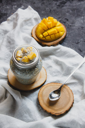 Chia pudding with yellow mango pieces on background of white linen cloth. Vegan healthy diet conceptの写真素材